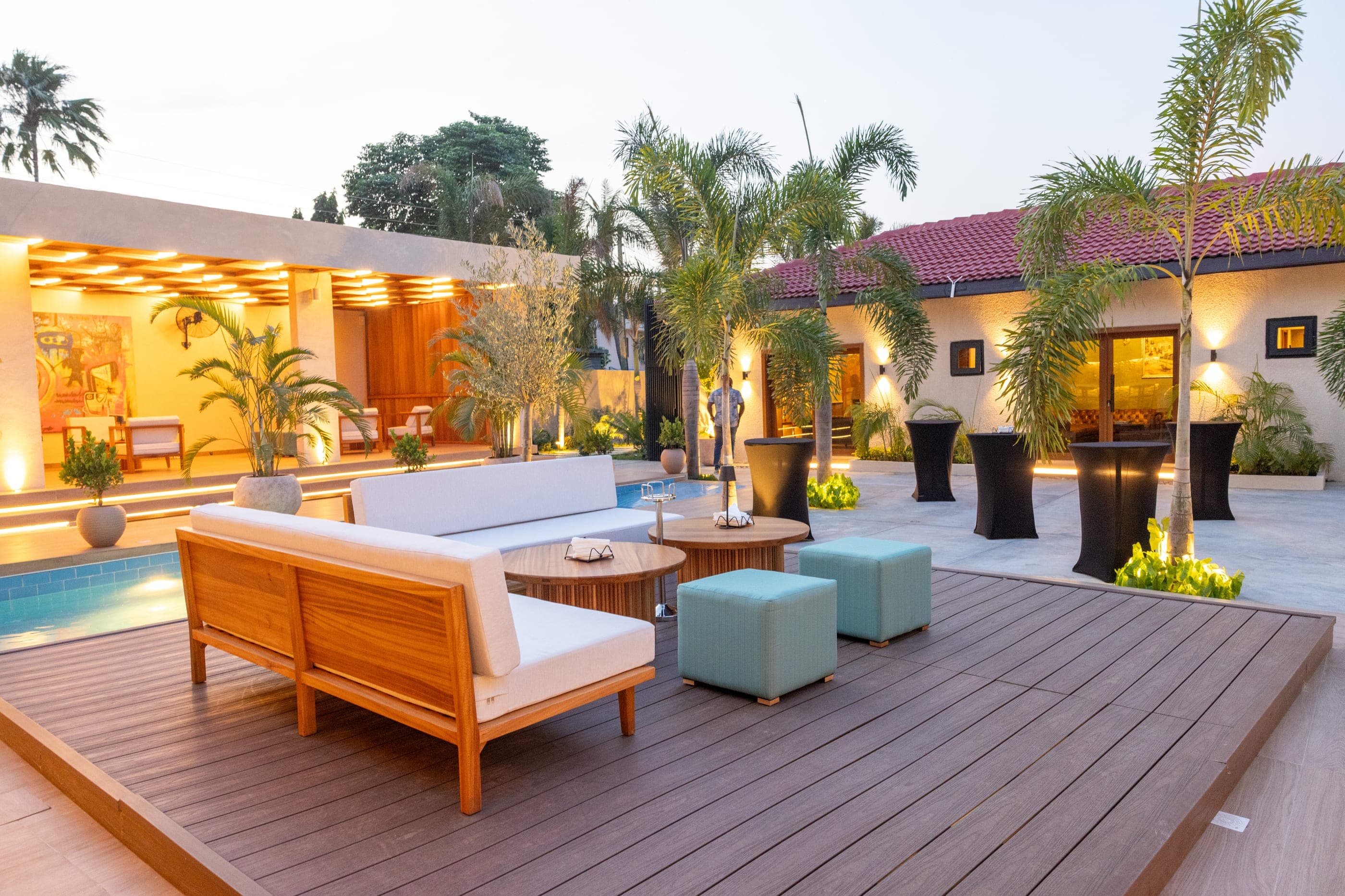 The outdoor cabana deck, timber daybeds and low tables beside the pool