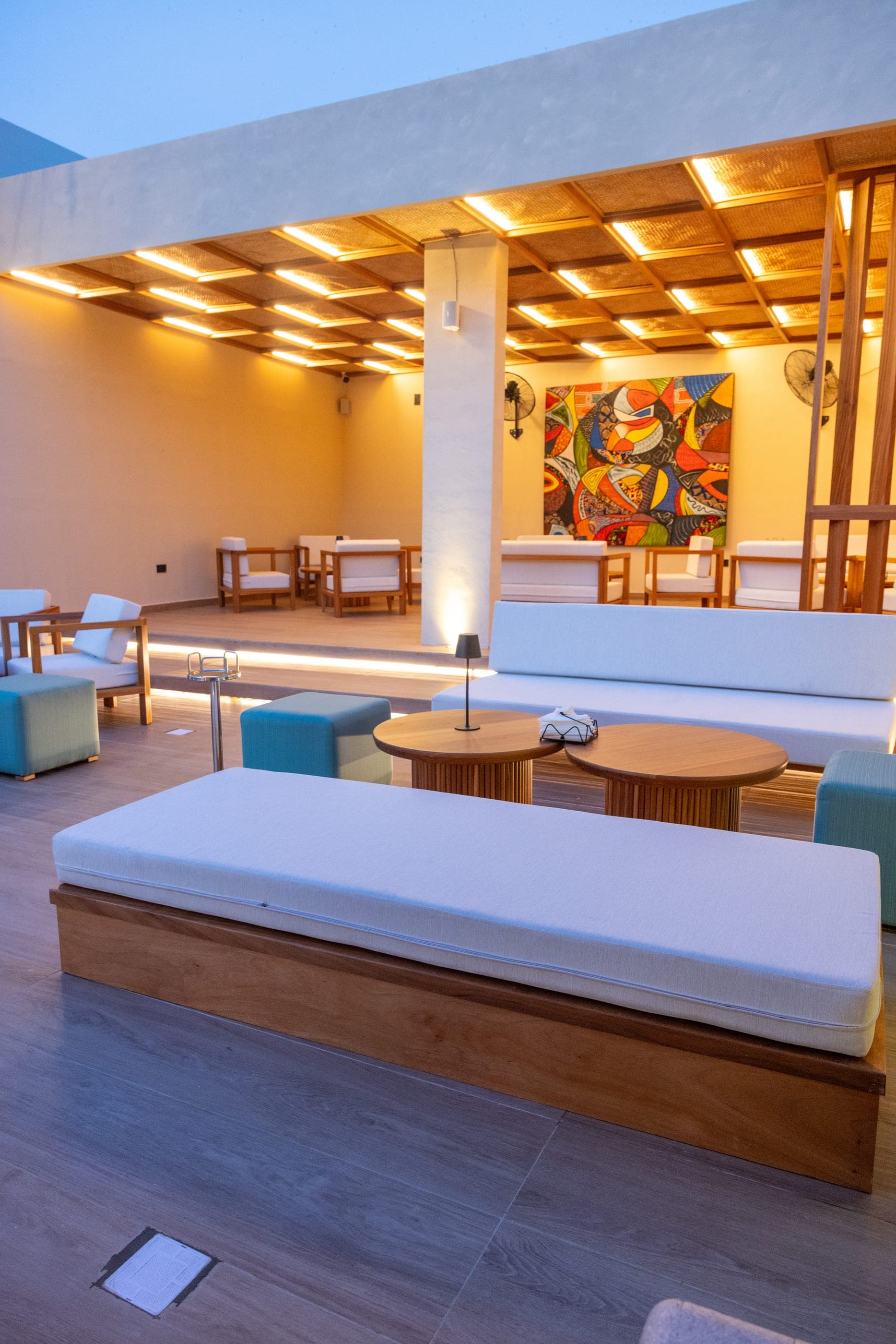 Outdoor daybeds and low tables on the deck, seen along the length of the terrace